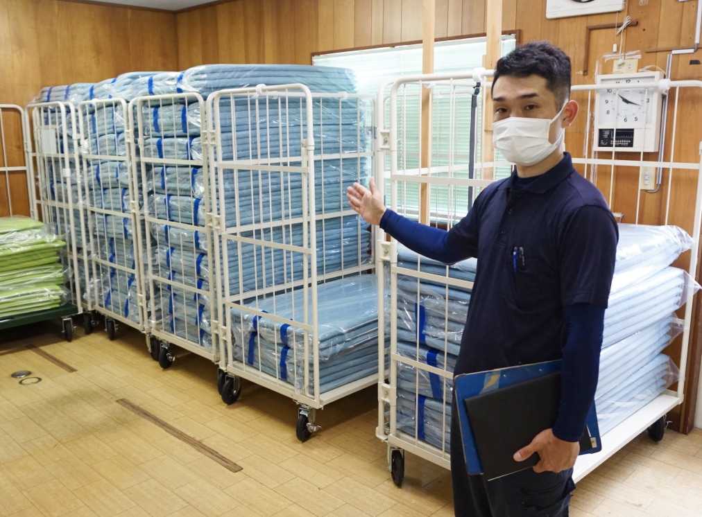 株式会社エビヌマのスタッフとクリーニング済み布団